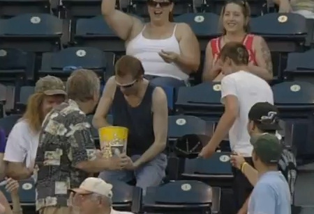 Il rattrape une balle de baseball avec son pot de popcorn (VIDEO)